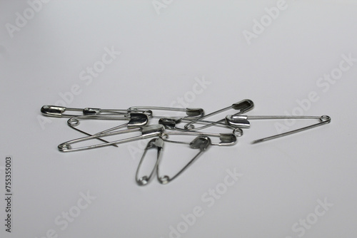 Some metal safety pins, isolated on white background photo