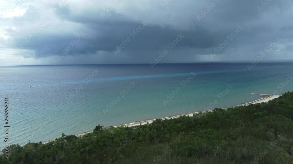 Approaching storm over Cozumel beach with clear waters and dark clouds, daytime Approaching storm over Cozumel beach with clear waters and dark clouds, daytime