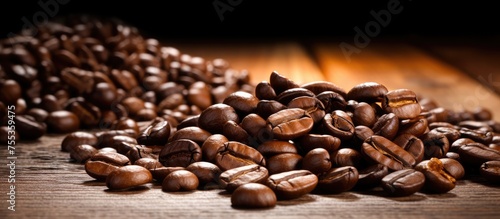 A large pile of coffee beans is neatly arranged on top of a rustic wooden table. The beans are dark and aromatic  with a rich brown color and a glossy appearance.