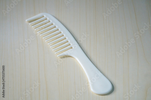 White comb with wooden background