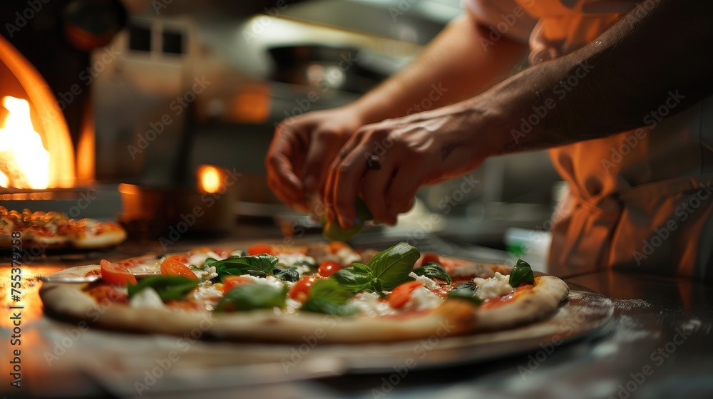 Pizza chef finishing the preparation of a tasty pizza in professional pizzeria restaurant kitchen.