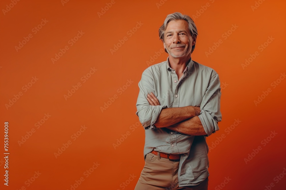 A man is standing in front of a red background, wearing a gray shirt A man is standing in front of a red background, wearing a gray shirt