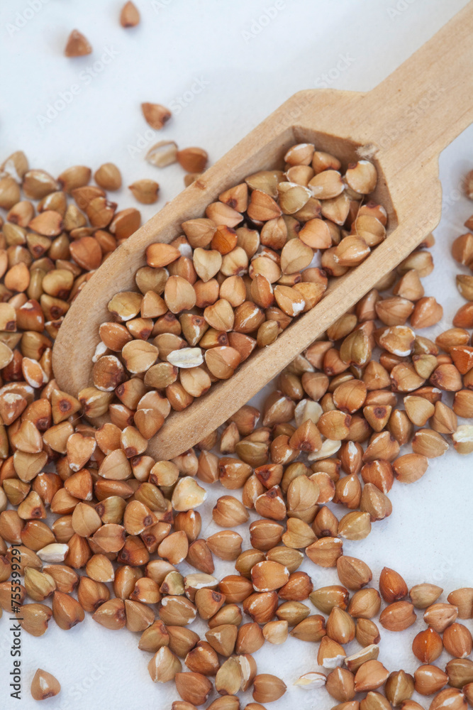 De hulled buckwheat with wooden scoop on white
De hulled buckwheat with wooden scoop on white