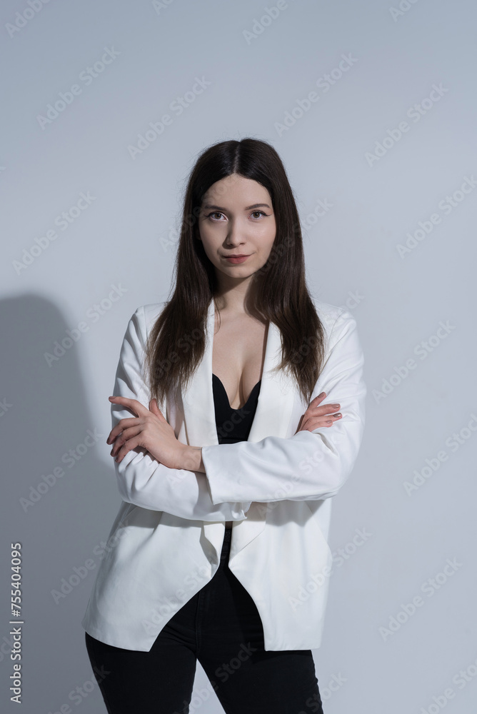 Portrait of attractive Caucasian young brunette woman in casual clothes, white jacket in studio. Style, fashion, elegance. Portrait of attractive Caucasian young brunette woman in casual clothes, white jacket in studio. Style, fashion, elegance.