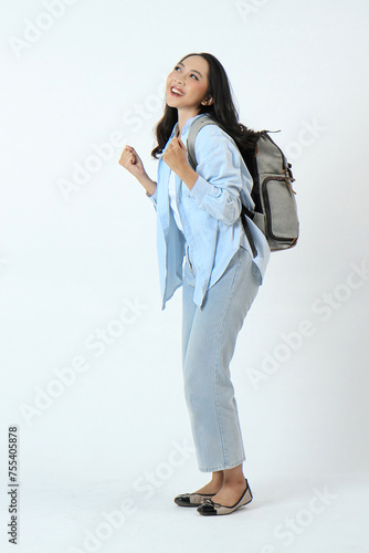 backview full leght shoot of happy asian Indonesian woman wearing casual attire and backpack on isolated background photo