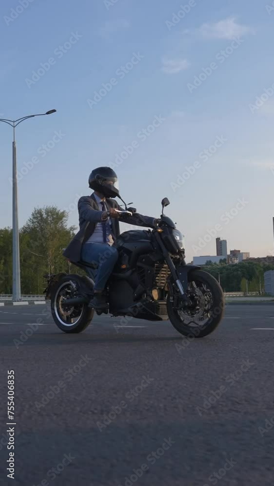 Caucasian man rides on an electric motorcycle. Vertical video. Caucasian man rides on an electric motorcycle. Vertical video.