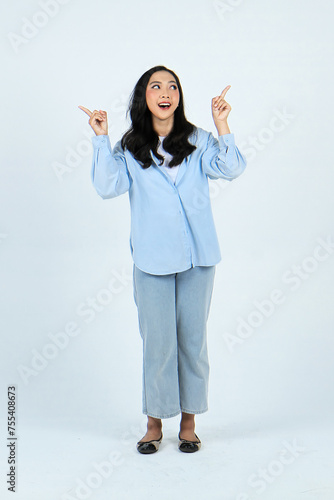 full leght shoot of happy asian Indonesian woman wearing casual attire, pointing finger on isolated background photo