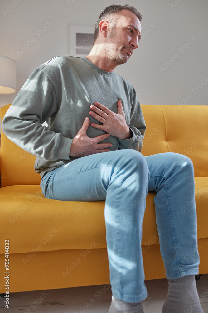Man with chest pain at home. Man with chest pain at home.