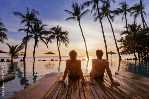 holidays, couple relaxing near swimming pool in luxury hotel resort at sunset on tropical island, honeymoon vacation travel