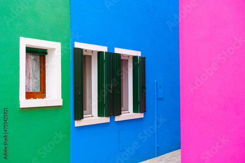 Blue, pink and green painted facades of the houses. Colorful architecture in Burano, Italy.