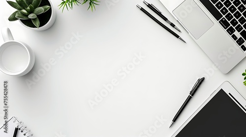 Modern minimalist workspace with laptop and accessories on a white desk from an aerial view  photo