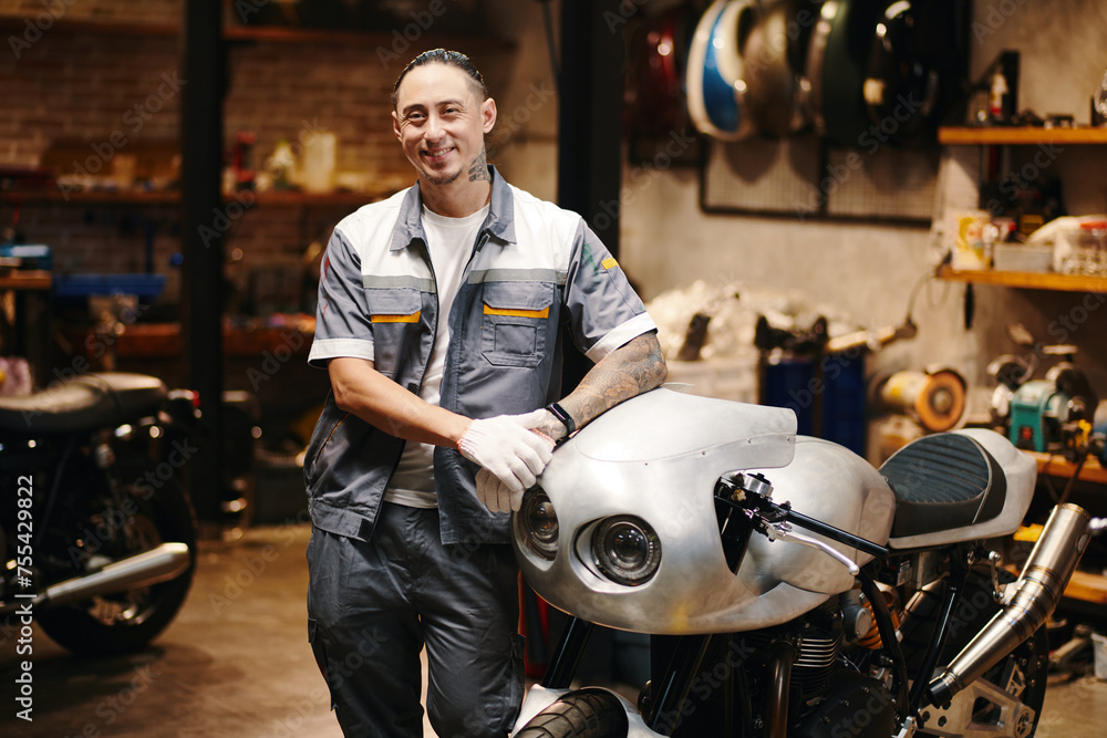 Portrait of positive confident motorcycle repair workshop owner