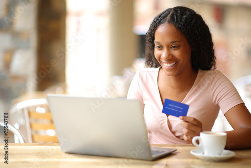 Black online buyer paying online in a restaurant photo