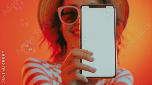 front view blur Beautiful woman face with reflect sun glass stretch arm to the front ponting and showing smartphone mockup blank white screen and smiling