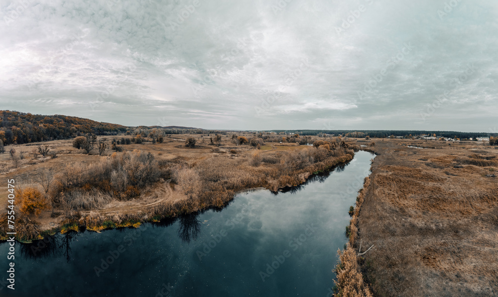 Aerial scenic panorama of river valley in autumn with grey cloudy sky in Ukraine countryside