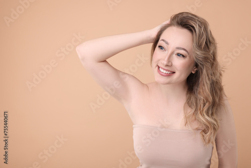 Portrait of smiling woman on beige background. Space for text