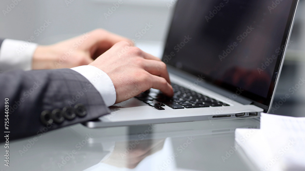Businessman in close-up working at a desk in the office with a laptop Businessman in close-up working at a desk in the office with a laptop