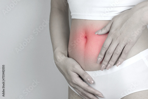 Stomach pain, and diarrhea. Woman's Hand holding the injured area of abdomen. Concept of women's health care to prevent gastritis, enteritis, and menstrual irregularities.