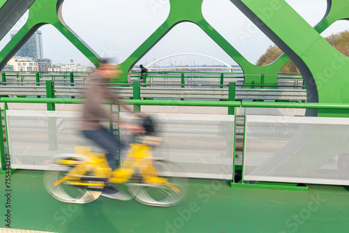 Blurred bicyclist on the Old bridge over the Danube river in Bratislava. Apolo bridge on the background. Slovakia