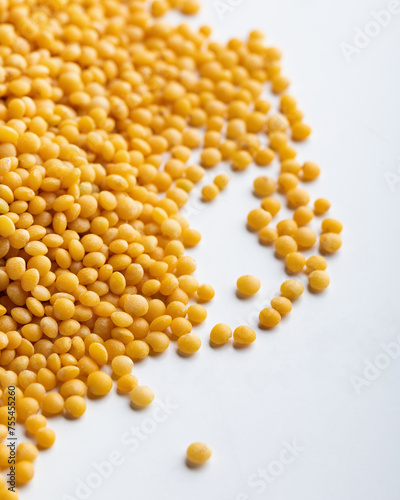 Yellow lentils on a white background. Macro. Selective focus.