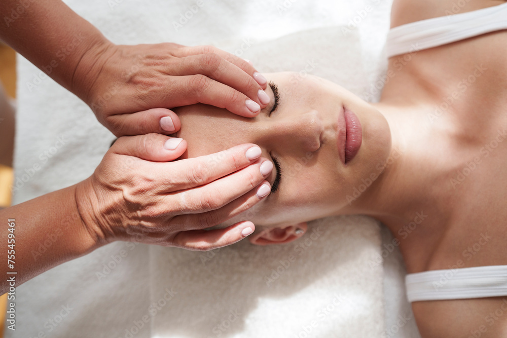 Hands of therapist massaging patient's head in treatment room Hands of therapist massaging patient's head in treatment room