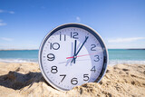 clock with time passing on a beach