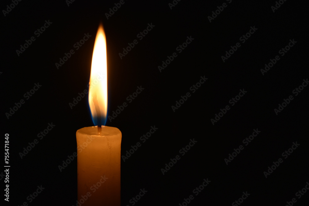Closeup of a lit candle in the dark Closeup of a lit candle in the dark