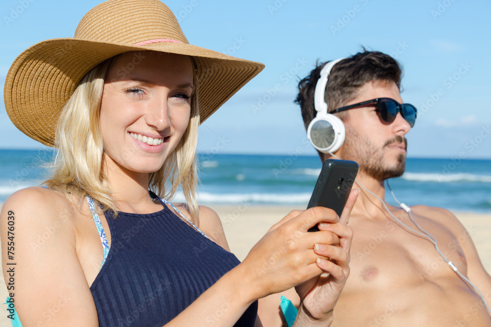 couple on the beach using technological devices