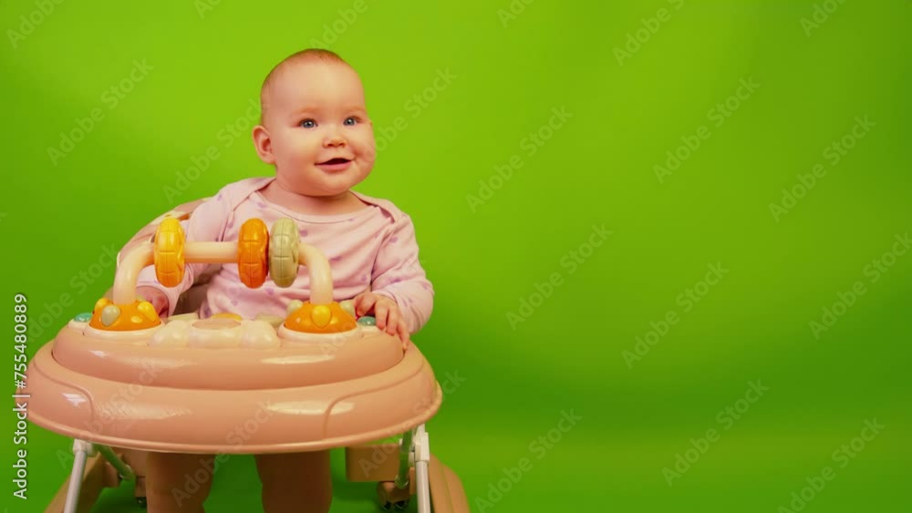 Baby Sitting in High Chair on Green Background. The baby is sitting in a walker Baby Sitting in High Chair on Green Background. The baby is sitting in a walker