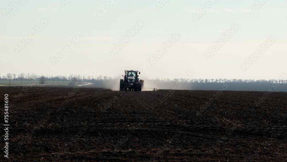 A huge field along which combine harvesters drive in early spring. Sowing or harvesting. Agro-farming industry, agricultural transport. A huge field along which combine harvesters drive in early spring. Sowing or harvesting. Agro-farming industry, agricultural transport.