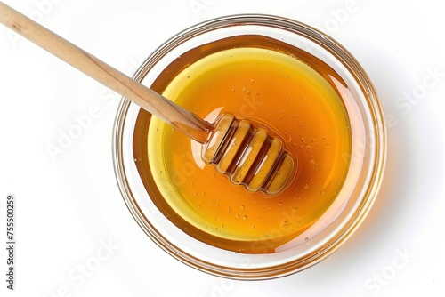 A spoonful of honey is sitting in a bowl. The spoon is wooden and is sticking out of the honey. And it looks delicious