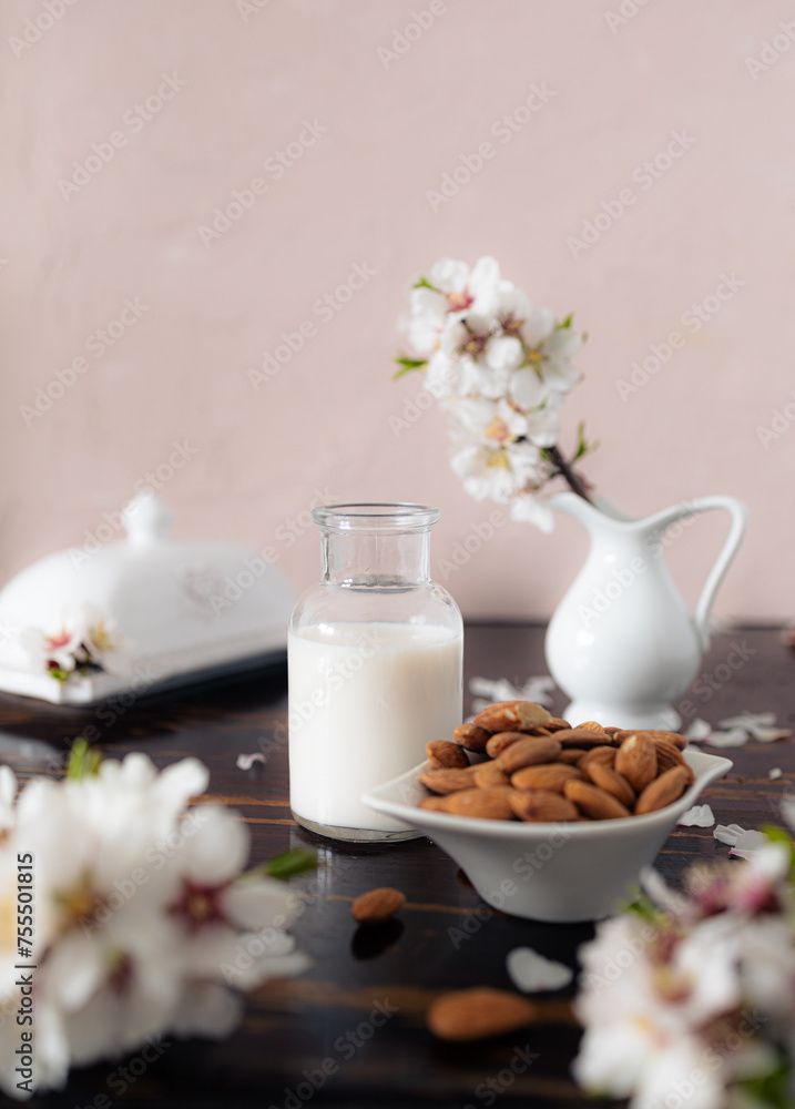 Almond milk with almonds and almond blossoms on the table: the vegan alternative to traditional milk Almond milk with almonds and almond blossoms on the table: the vegan alternative to traditional milk