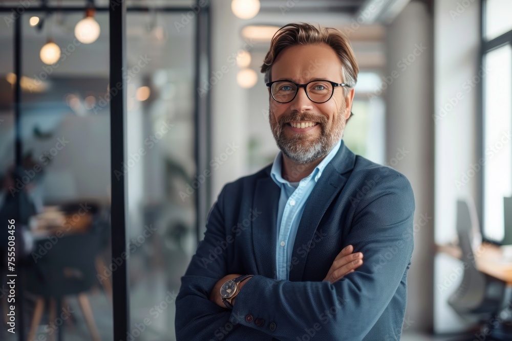 A man in a suit and glasses is smiling and posing for a picture. He is wearing a blue jacket and has his arms crossed. Concept of professionalism and confidence A man in a suit and glasses is smiling and posing for a picture. He is wearing a blue jacket and has his arms crossed. Concept of professionalism and confidence