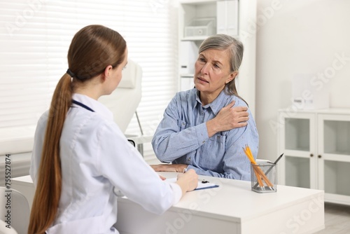 Arthritis symptoms. Doctor consulting patient with shoulder pain in hospital photo