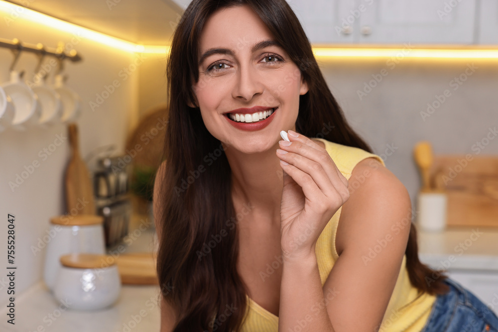 Beautiful woman taking vitamin pill at home Beautiful woman taking vitamin pill at home
