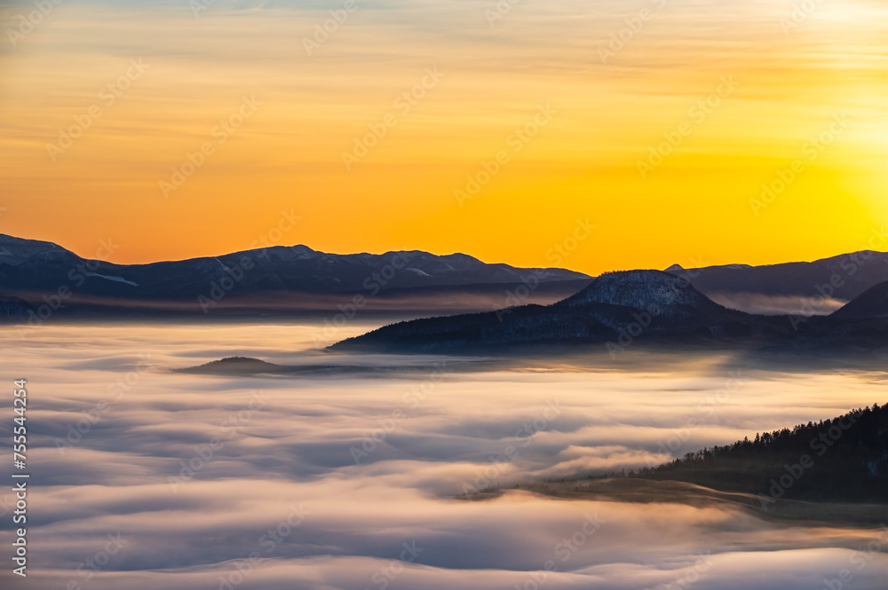 朝の峰から見るシルクのような雲と山々のシルエット。