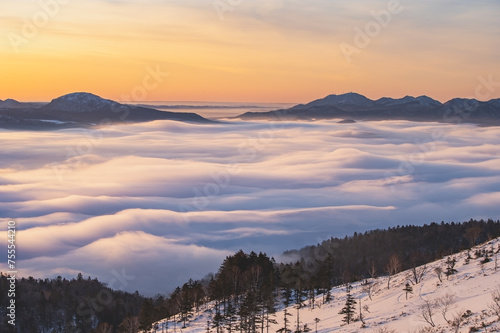 朝の峰から見るシルクのような雲と山々のシルエット。