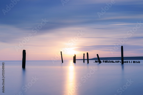Low angle view of beautiful sunrise along the coast of the UNESCO Wadden Sea on Dutch island photo