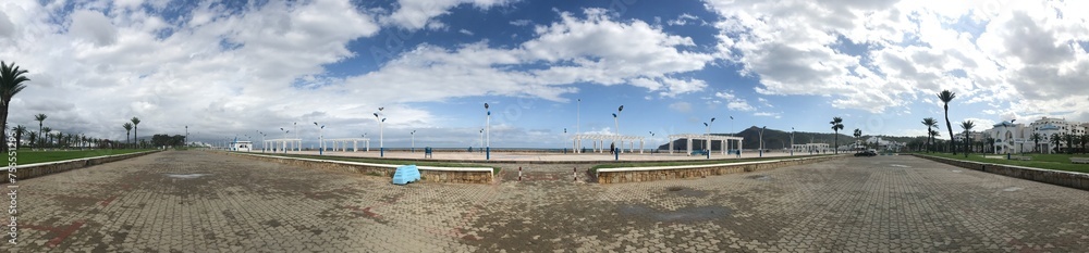 Panoramic view of coastal walkway in cloudy day