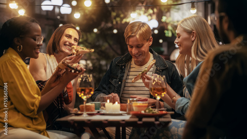 Young Multiethnic Friends Enjoying a Night Out in a Cafe. Eating Delicious Italian Pizza. Young Men and Women Having Fun Conversations on a Terrace  Enjoying Tasty Food and Beverages