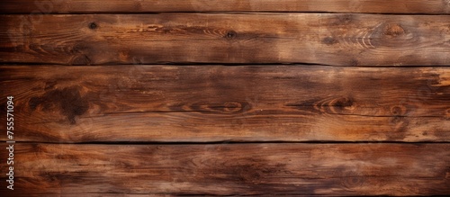 A detailed view of an aged wooden plank wall, showcasing the rich texture and natural grain patterns of the weathered wood.