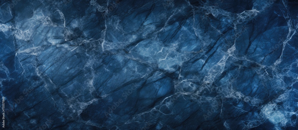 A close-up view of a dark blue marble texture background, showcasing intricate cracks and patterns. The deep blue hues create a mysterious and elegant atmosphere, perfect for adding a touch of