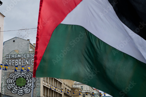 Palestine Flags with the drawing of Remember Srebrenica on the wall. Free Palestine.