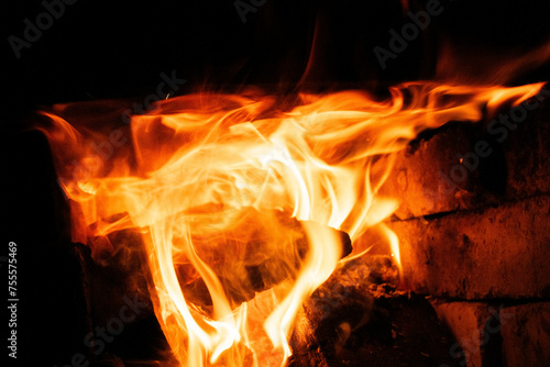 Wood in the flames of cozy fireplace