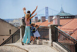 Happy young family on trip lift hands up in Lisbon, Portugal