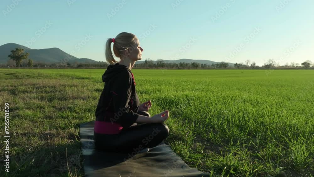 Woman meditating, yoga meditation practice in nature. Girl is sitting in lotus pose. Woman meditating, yoga meditation practice in nature. Girl is sitting in lotus pose.