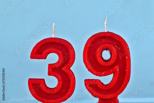 close up on red number thirty ninth birthday candle on a white background.
 photo