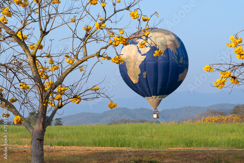 A globe-shaped balloon floats low in a flower garden. Minimal creative concept of travel, sustainablity, love, ecology. Earth Day card. World provided by NASA.