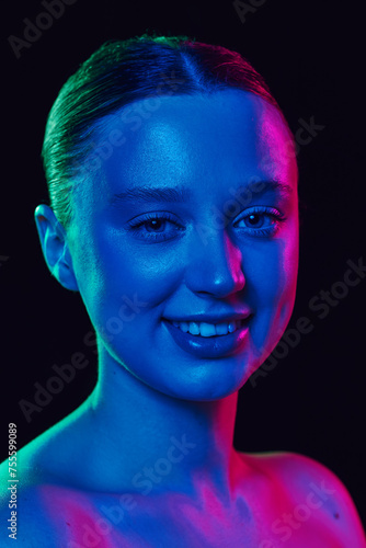Closeup portrait of beauty woman face with well-kept, healthy, smooth skin in neon light against black studio background. Concept of spa procedures, cosmetology, antiaging and skincare products. Ad