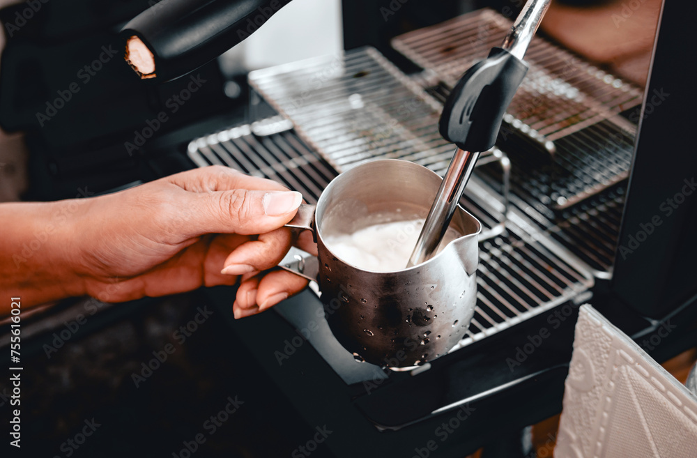 Close-up of Barista hand using high-pressure steam-operated milk frother to prepare a cappuccino and latte coffee milk